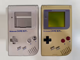 Two Gameboys - The left one has been retro bleached, and the right one is still in its original yellowed condition.